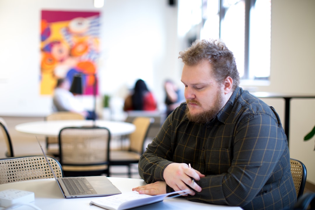 A focused architect in a bright, modern office meticulously reviews a set of blueprints, illustrating the expert planning required for effective SEO strategies.