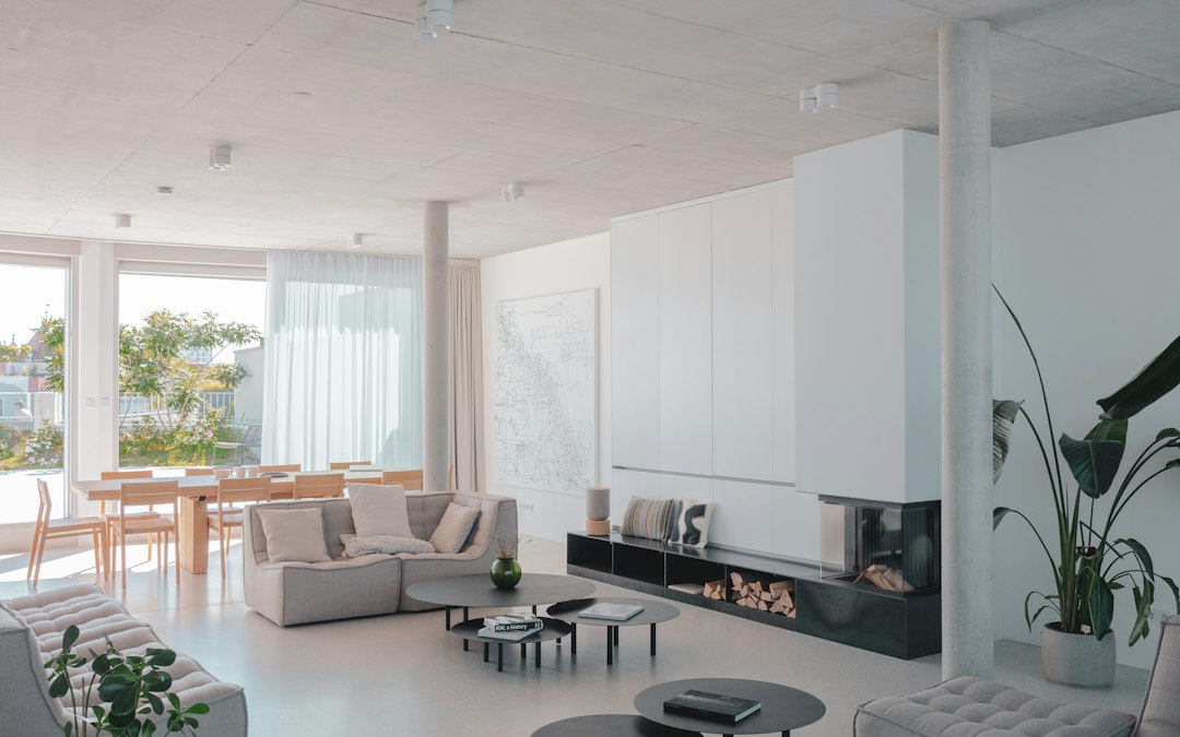 Bright, airy interior of a modern vacation home with minimalist furniture and a large window looking out onto a scenic view.